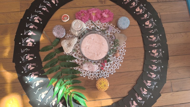 L'autel du cercle vu de dessus : cartes disposées en couronne, fleurs et bougie